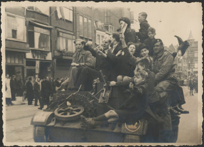 879271 Afbeelding van een Bren Gun Carrier, volgeladen met feestvierende burgers, tijdens de intocht van de ...